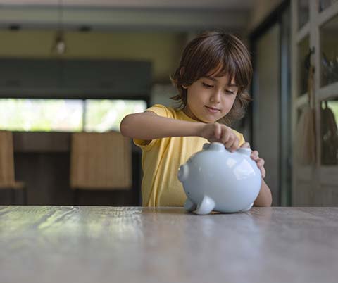 Kid opening a piggy bank