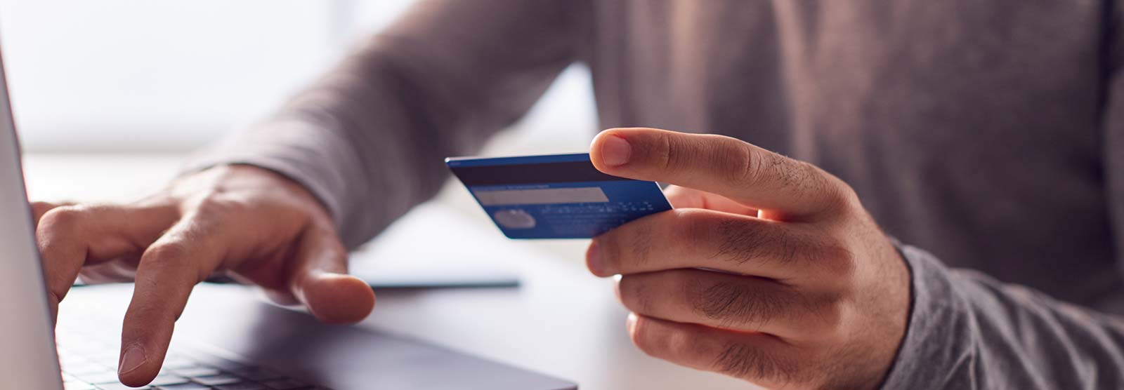 Man using a card at a laptop